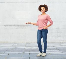 Image showing happy african woman holding something imaginary