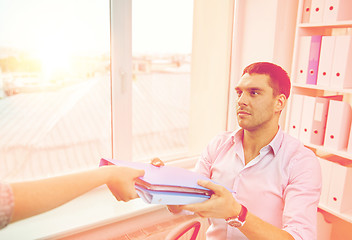 Image showing businessman taking folder from secretary in office