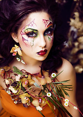 Image showing beauty woman with face art and jewelry from flowers orchids clos