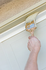 Image showing Professional Painter Cutting In With Brush to Paint Garage Door 