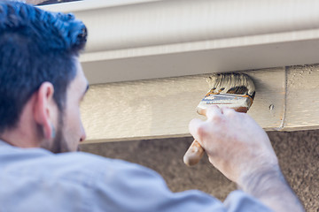 Image showing Professional Painter Using Brush to Paint House Fascia Under Rai