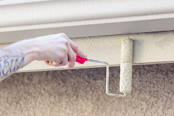 Image showing Professional Painter Using Small Roller to Paint House Fascia