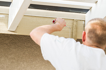 Image showing Professional Painter Using Small Roller to Paint House Fascia