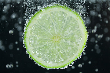 Image showing Lime slice falling into water