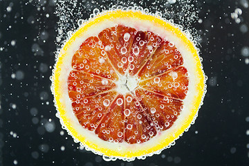 Image showing Orange citrus slice falling into water