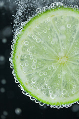 Image showing Lime slice falling into water