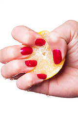 Image showing Hand with manicured nails squeeze lemon on white