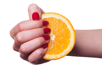 Image showing Hand with manicured nails touch an orange on white