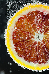 Image showing Orange citrus slice falling into water