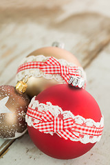 Image showing Three Christmas baubles on rustic wood