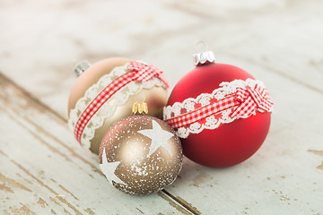 Image showing Three Christmas baubles on rustic wood