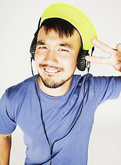 Image showing young asian man in hat and headphones listening music on white b