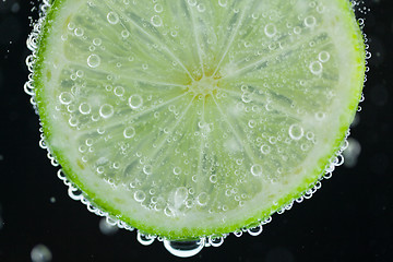 Image showing Lime slice falling into water