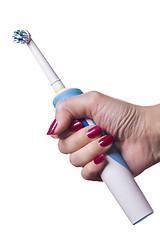 Image showing Hand holds electric toothbrush against white