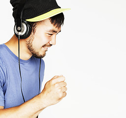 Image showing young asian man in hat and headphones listening music on white b