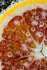 Image showing Orange citrus slice falling into water