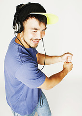 Image showing young asian man in hat and headphones listening music on white b