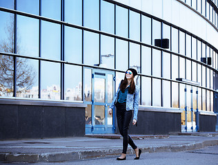 Image showing young pretty girl near business building walking