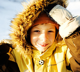 Image showing little cute boy in hood with fur on snow outside