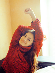 Image showing young pretty real woman in red sweater and scarf all over her fa