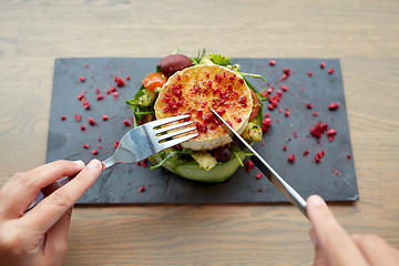 Image showing woman eating goat cheese salad at restaurant