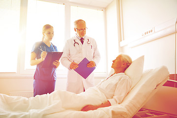 Image showing doctor and nurse visiting senior woman at hospital