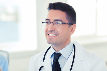 Image showing smiling male doctor in white coat and eyeglasses