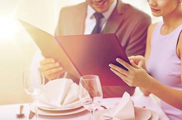 Image showing close up of happy couple with menu at restaurant