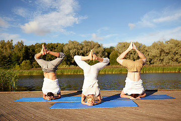 Image showing people making yoga headstand on mat outdoors