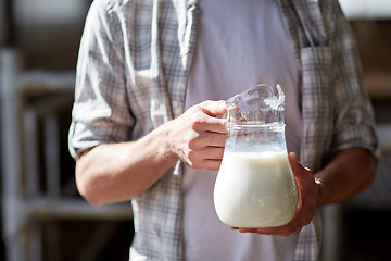 Image showing close up of man or farmer with milk on dairy farm