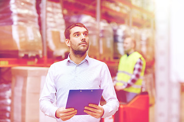 Image showing businessman with clipboard at warehouse