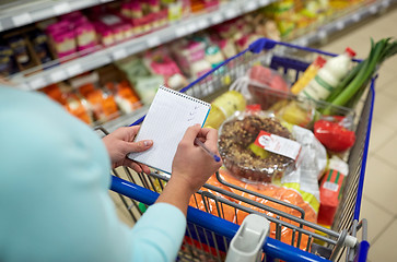 Image showing woman with food in shopping cart at supermarket