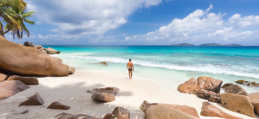 Image showing Man enjoying Anse Patates picture perfect beach on La Digue Island, Seychelles.