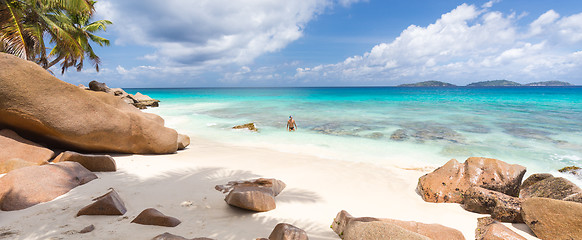 Image showing Man enjoying Anse Patates picture perfect beach on La Digue Island, Seychelles.