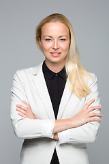 Image showing Business woman standing with arms crossed against gray background.