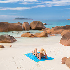 Image showing Woman sunbathing at Anse Lazio picture perfect beach on Praslin Island, Seychelles.