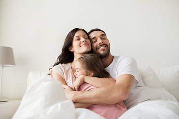 Image showing happy family hugging in bed at home