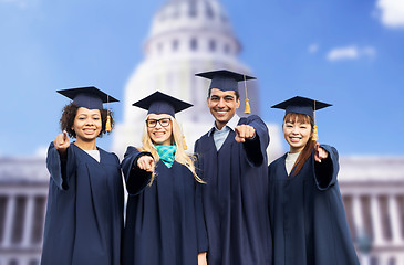 Image showing happy students or bachelors pointing finger at you