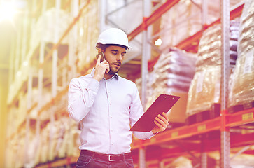 Image showing man with clipboard and smartphone at warehouse