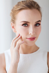 Image showing beautiful woman in white dress touching her face