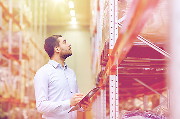 Image showing businessman with clipboard at warehouse