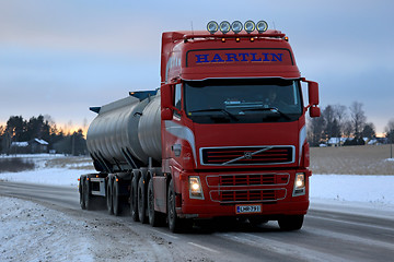 Image showing Red Volvo FH Tank Truck Delivers at Dusktime