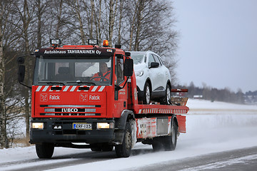 Image showing Red Tow Truck Tows a Breakdown Car in Winter