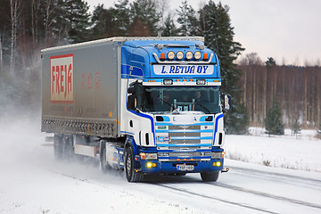 Image showing Scania 164L Semi Truck Transports Goods on Snowy Road