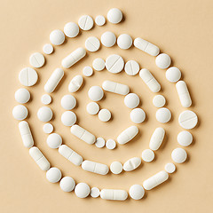 Image showing white medicine pills on beige background