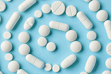 Image showing white medicine pills on blue background