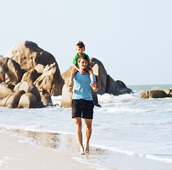 Image showing happy family on beach playing, father with son walking sea coast