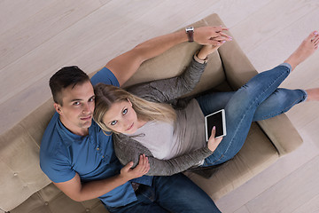 Image showing youg couple in living room with tablet top view