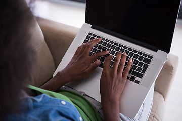 Image showing African American women at home in the chair using a laptop