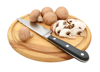 Image showing Knife with sliced and whole chestnut mushrooms on chopping board